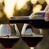Two glasses of red wine being poured