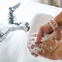 washing hands with soap at faucet
