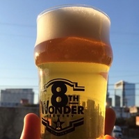 Eighth 8th Wonder Brewery glass of beer with skyline in background