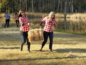 Girls carry bales of hay on the Bachelor