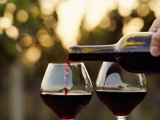 Two glasses of red wine being poured